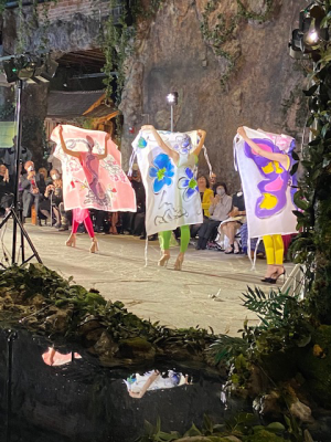 Three models wearing colorful dresses