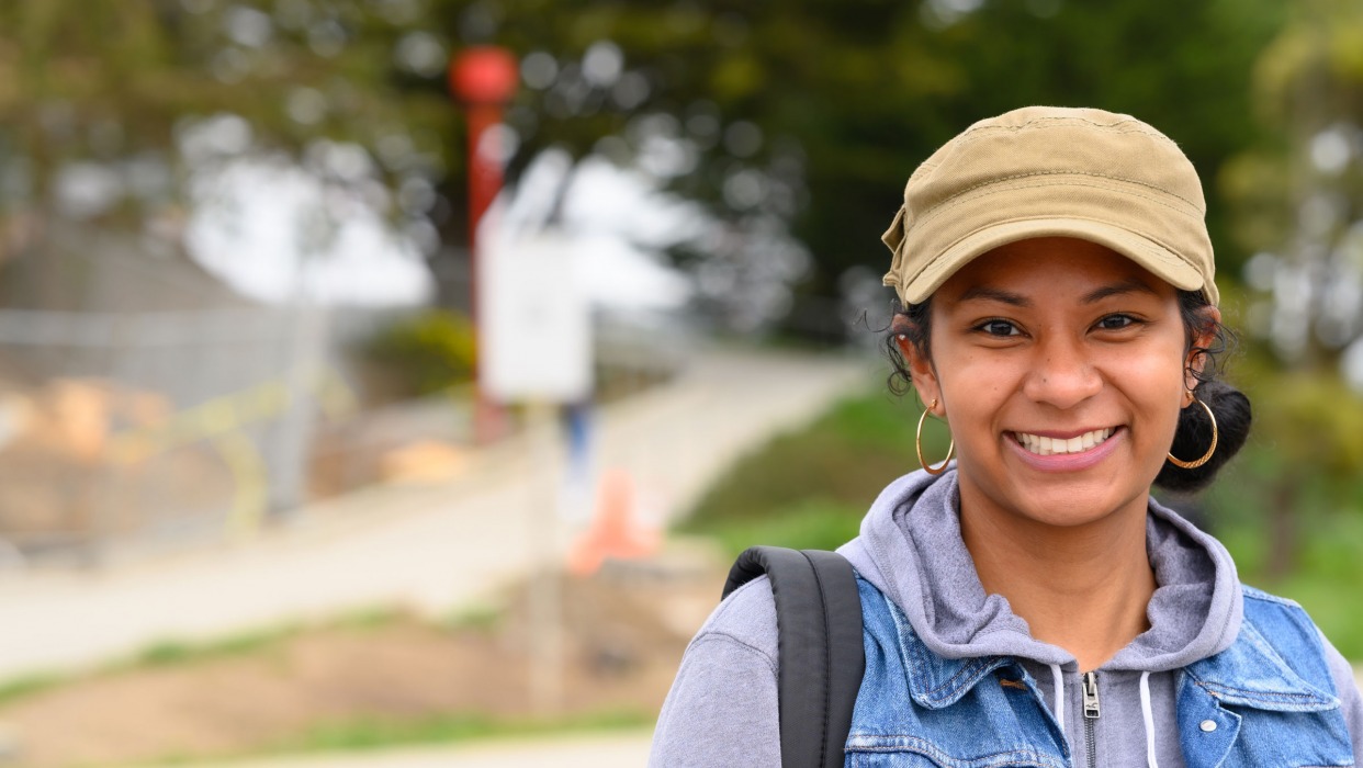 Female Student stands in front of Ocean Campus on their way to class.