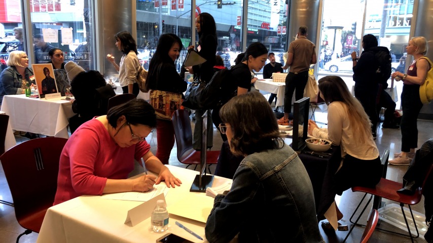 People filling out forms at Career Fair