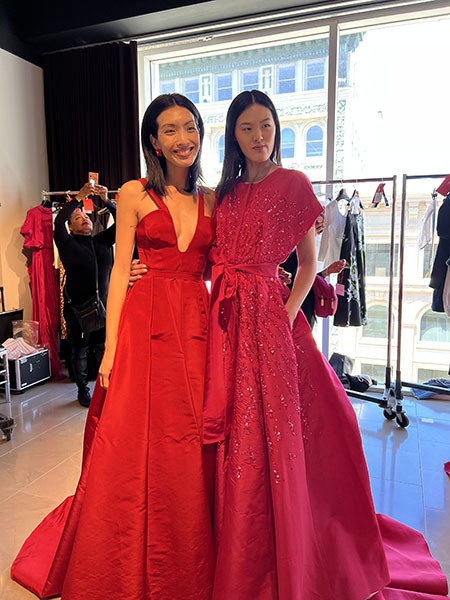 Model in red dress with model in pink dress
